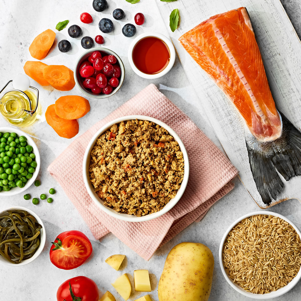 Naturo dog food in bowl surrounded by recipe ingredients