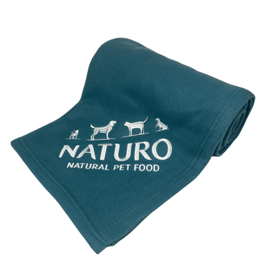 Teal blanket with Naturo Natural Pet Food logo on a light blue background