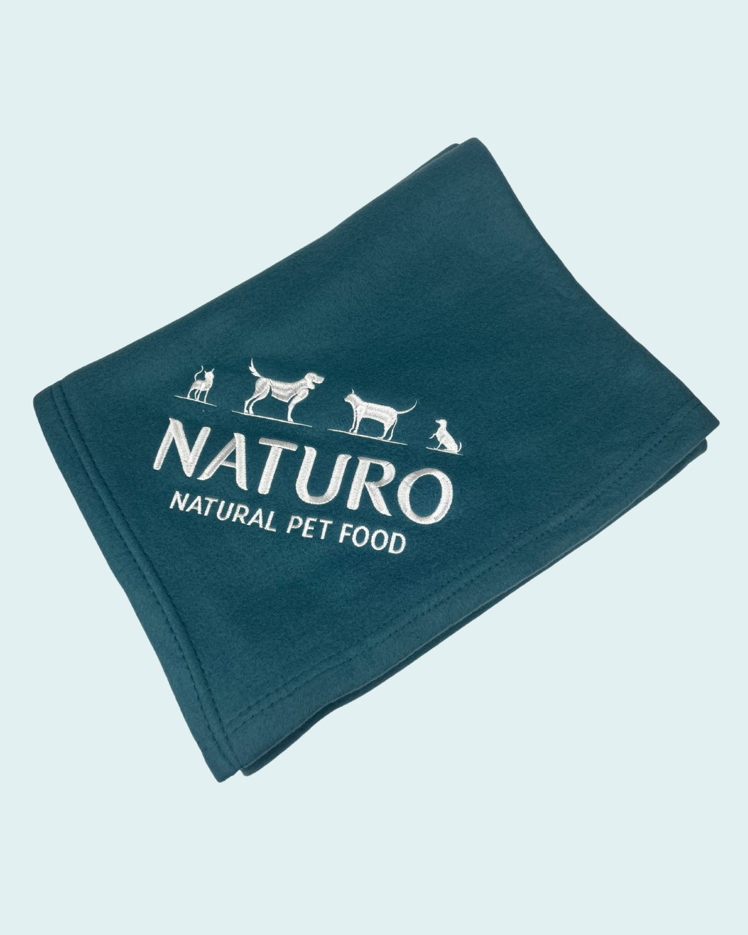 Folded blue blanket with 'Naturo Natural Pet Food' logo on a light blue background