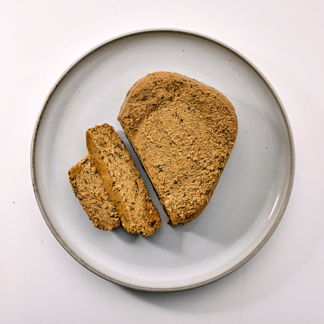 Naturo dog food trays on a white plate with pale background sliced on plate