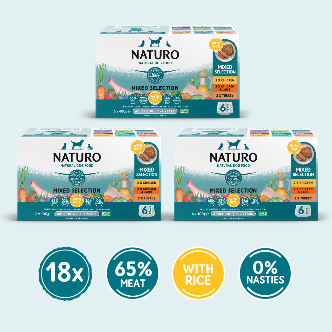 A variety of Naturo brand dog food trays in a stack, indicating a mixed selection with rice variety pack containing 18 trays, with 65% meat and 0% nasties.