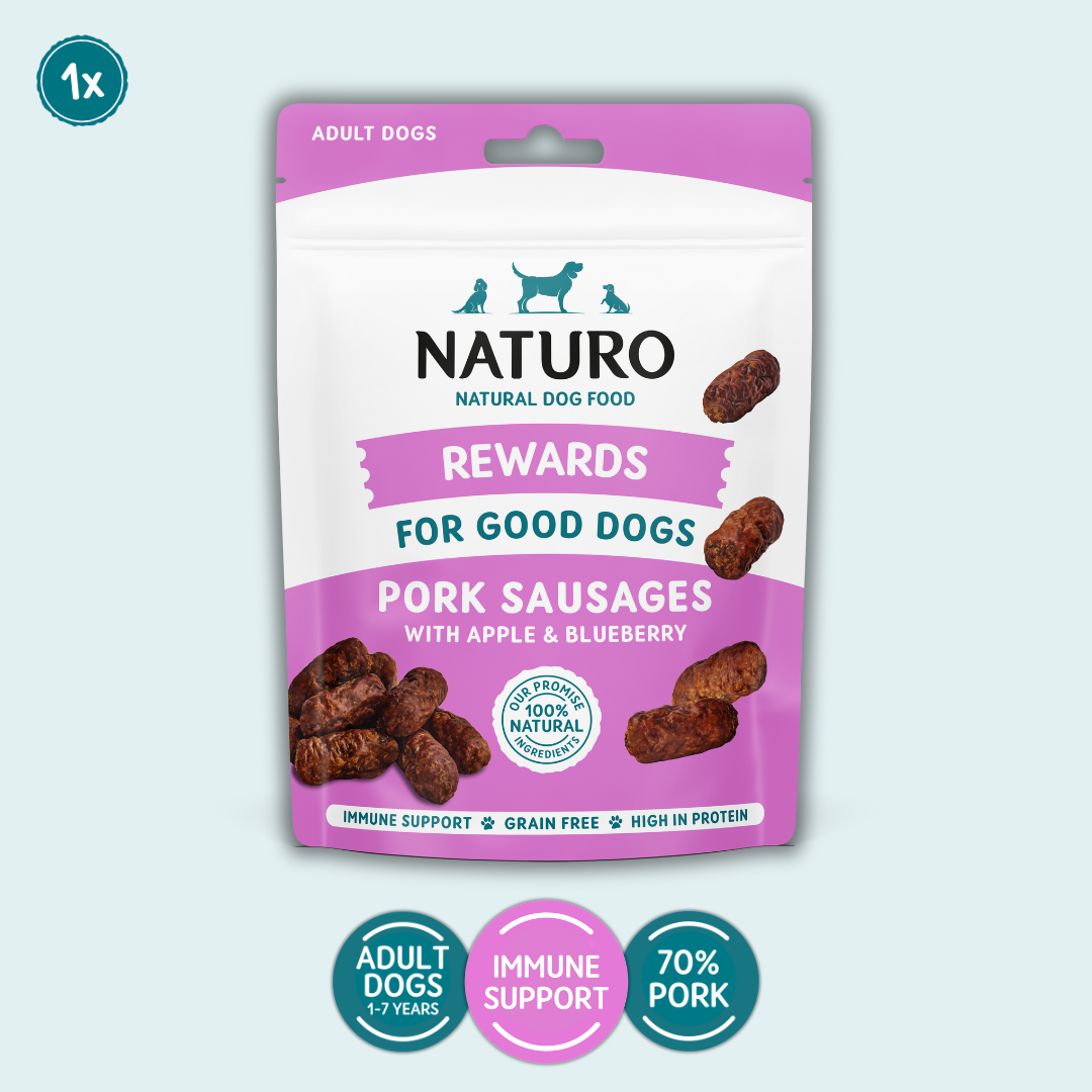 Package of Naturo dog treats for adult dogs with pork sausages on a light blue background