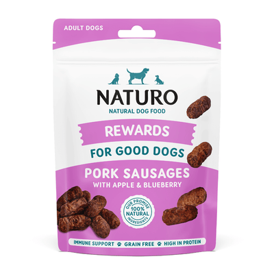 Package of Naturo dog treats for adult dogs with pork sausages on a light blue background