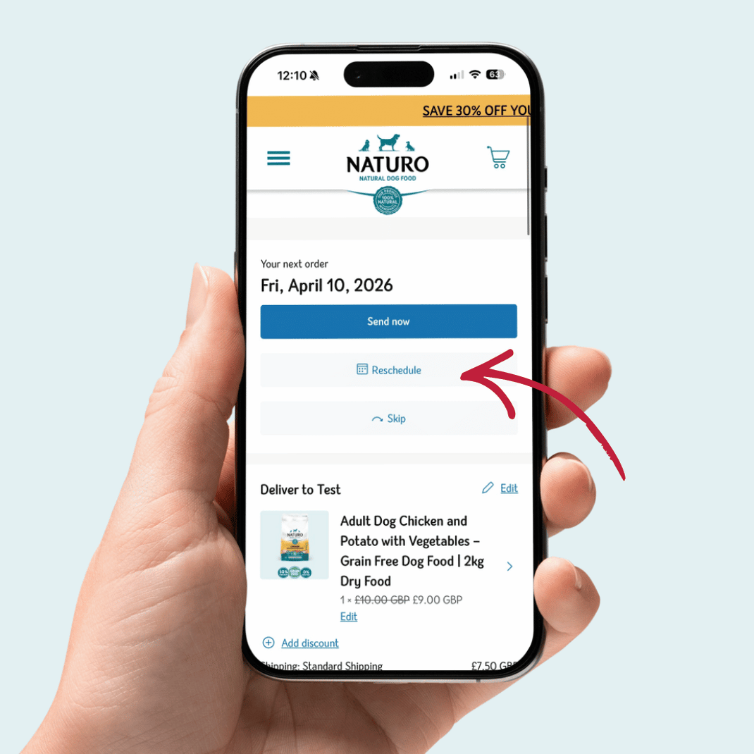 Hand holding a smartphone displaying the NATURO app with a scheduled order for dog food.